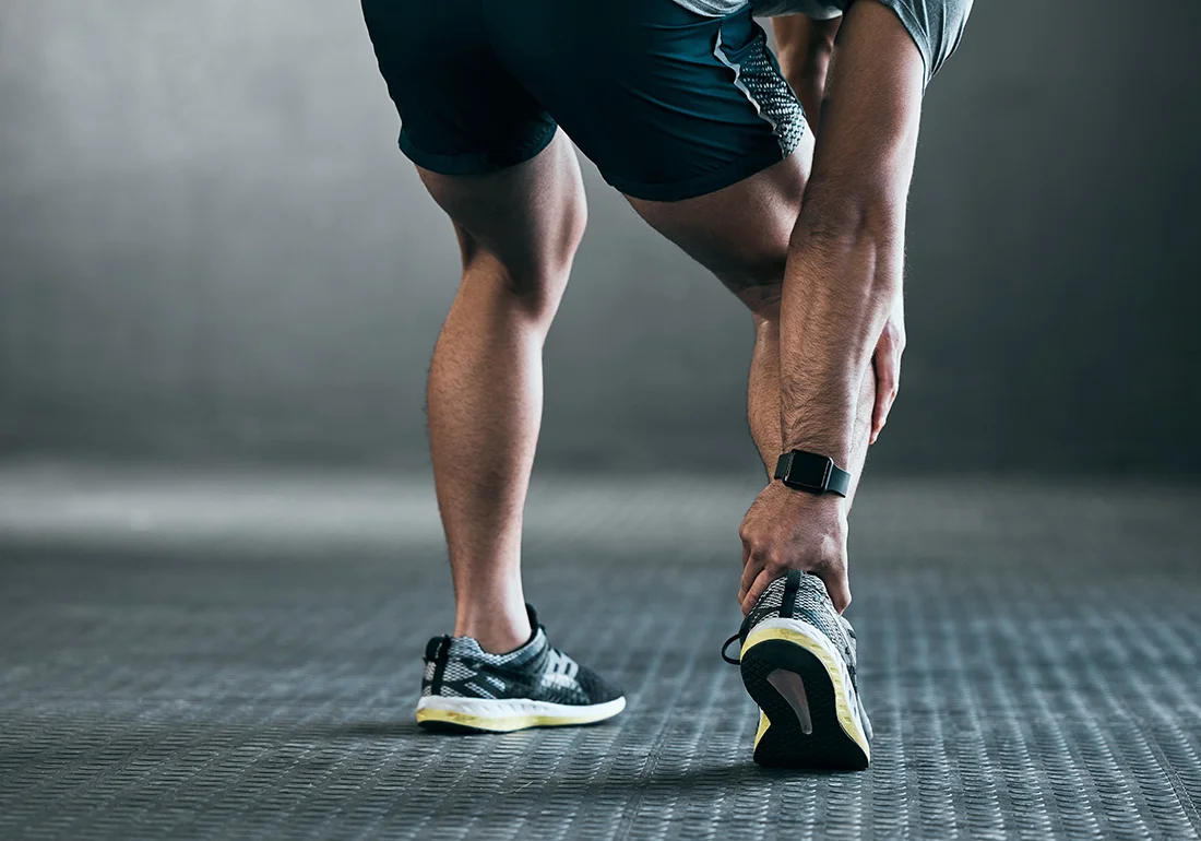 Man holding the back of his ankle due to discomfort
