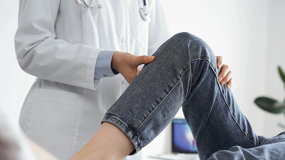 Patient consulting a knee specialist during an assessment for persistent knee pain.