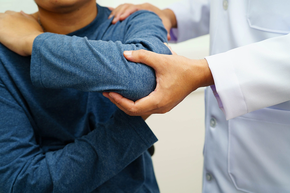 Orthopaedic doctor guiding a patient through a rehabilitation stretch.