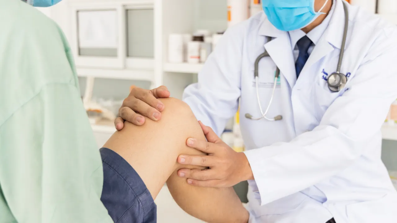 Orthopedic surgeon examining patient with knee injury