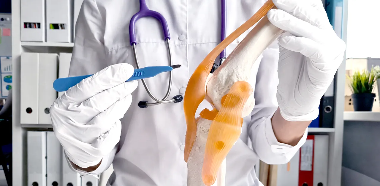 Orthopedic surgeon reviewing a digital knee X-ray on a tablet with a patient during a consultation.